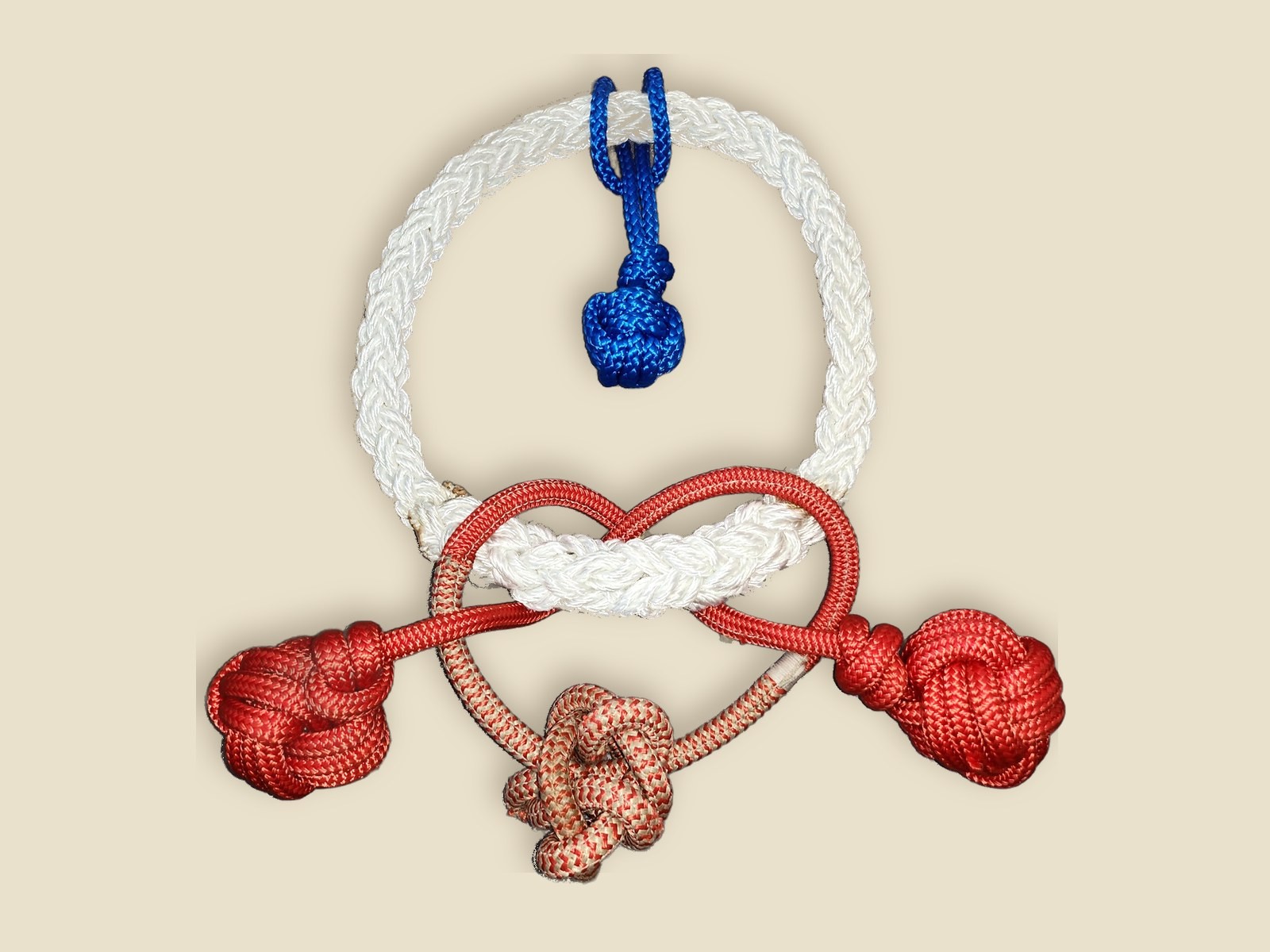 Hand-tied rope pieces: two red monkey's fist knots, a red and white knotted loop, a white braided ring and a small blue knot