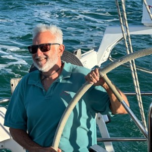 Skip at the helm of a sailboat
